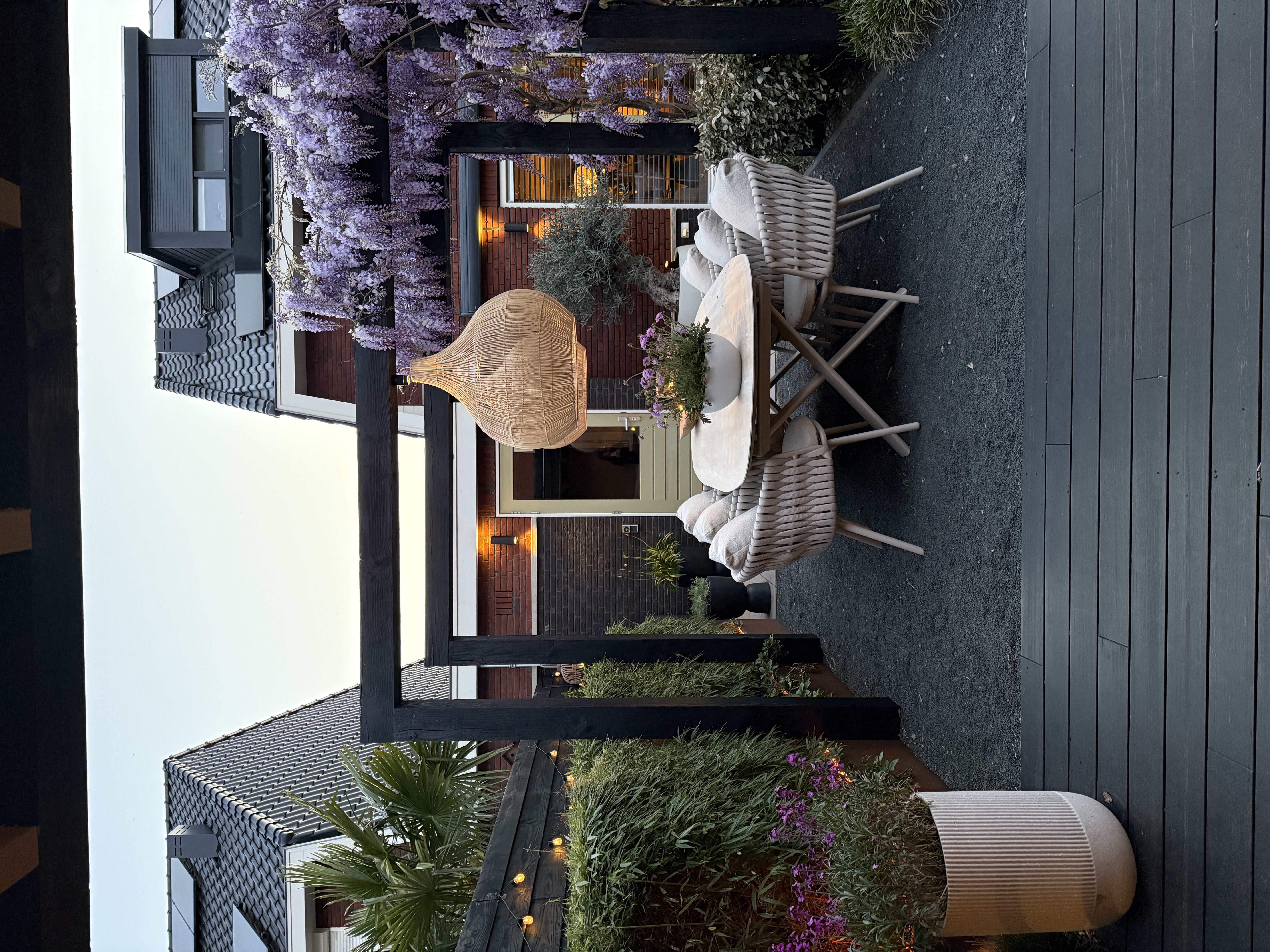 Pergola sfeervolle tuin rotan hanglampen blauwe regen wisteria