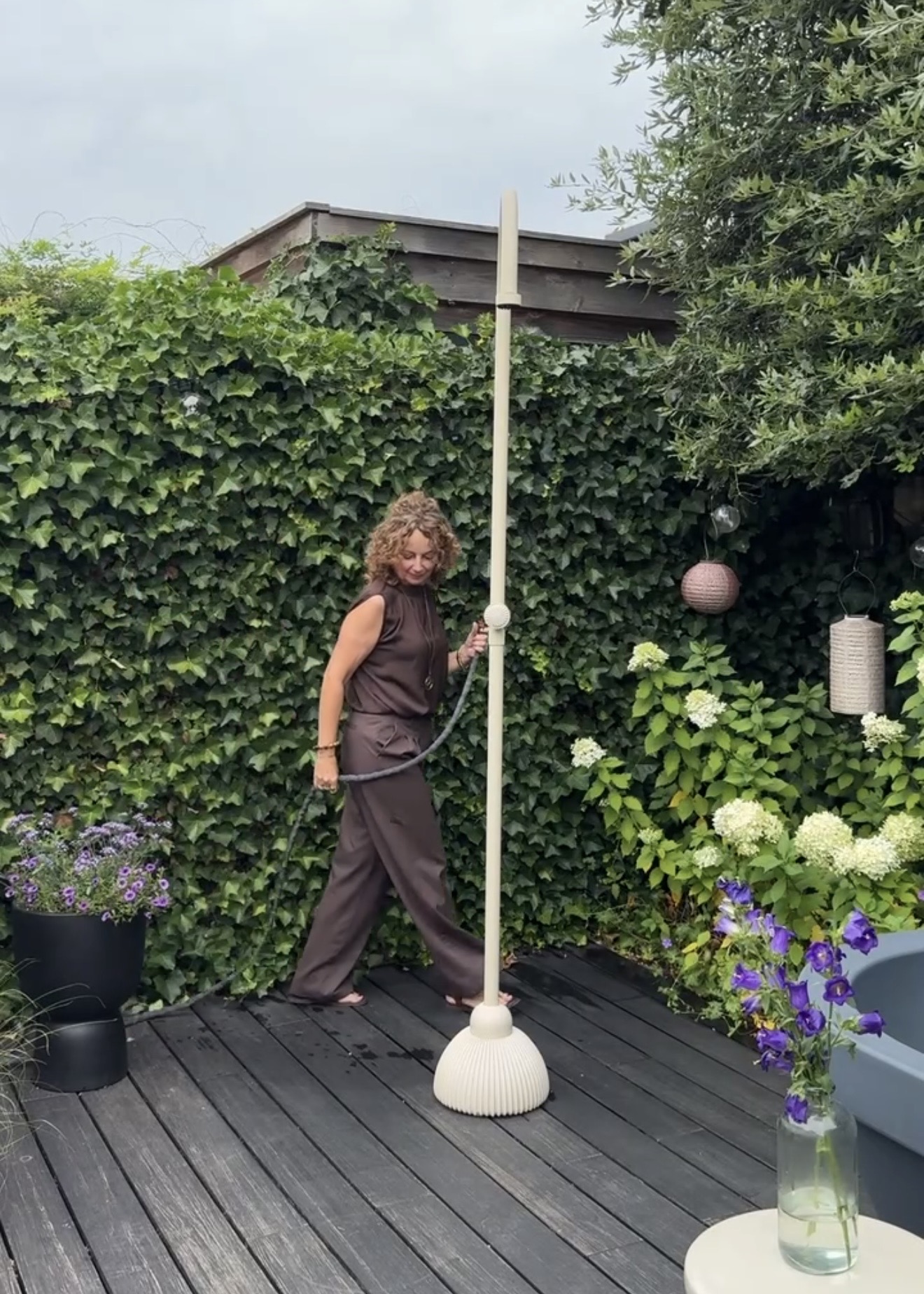 Buitendouche in tuin met tuinslang